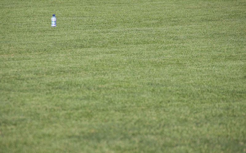 Lonely-bottle-on-grass-in-front-of-the-leaning-leaning-tower-in-Pisa-Italy