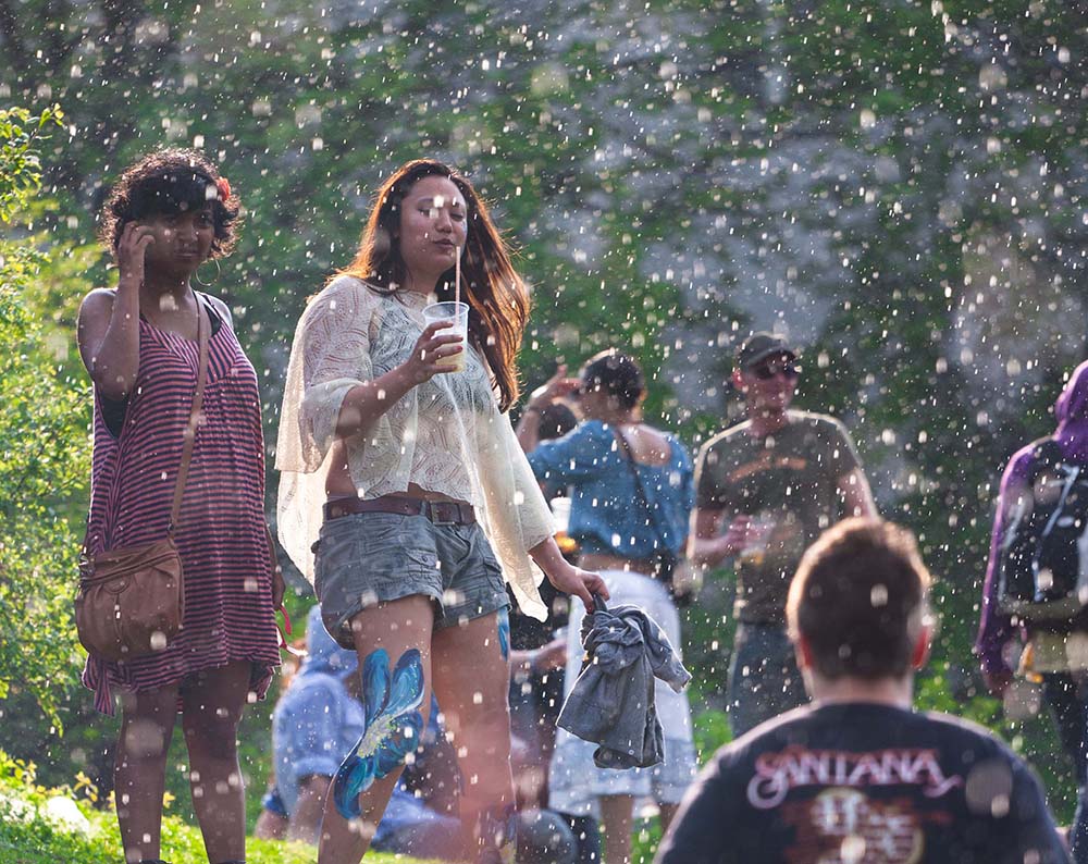 People enjoying a short shower of rain while the sun is still shining in Görlitzer Park at Mayfest on May 1st 2012 in Berlin